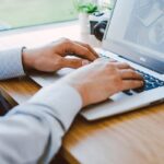 Un homme travaillant sur un ordinateur portable dans un bureau moderne.