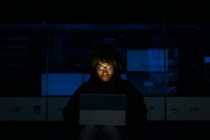Une femme profondément absorbée par la programmation sur un ordinateur portable la nuit dans un centre de données.
