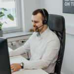un homme portant un casque assis devant un ordinateur