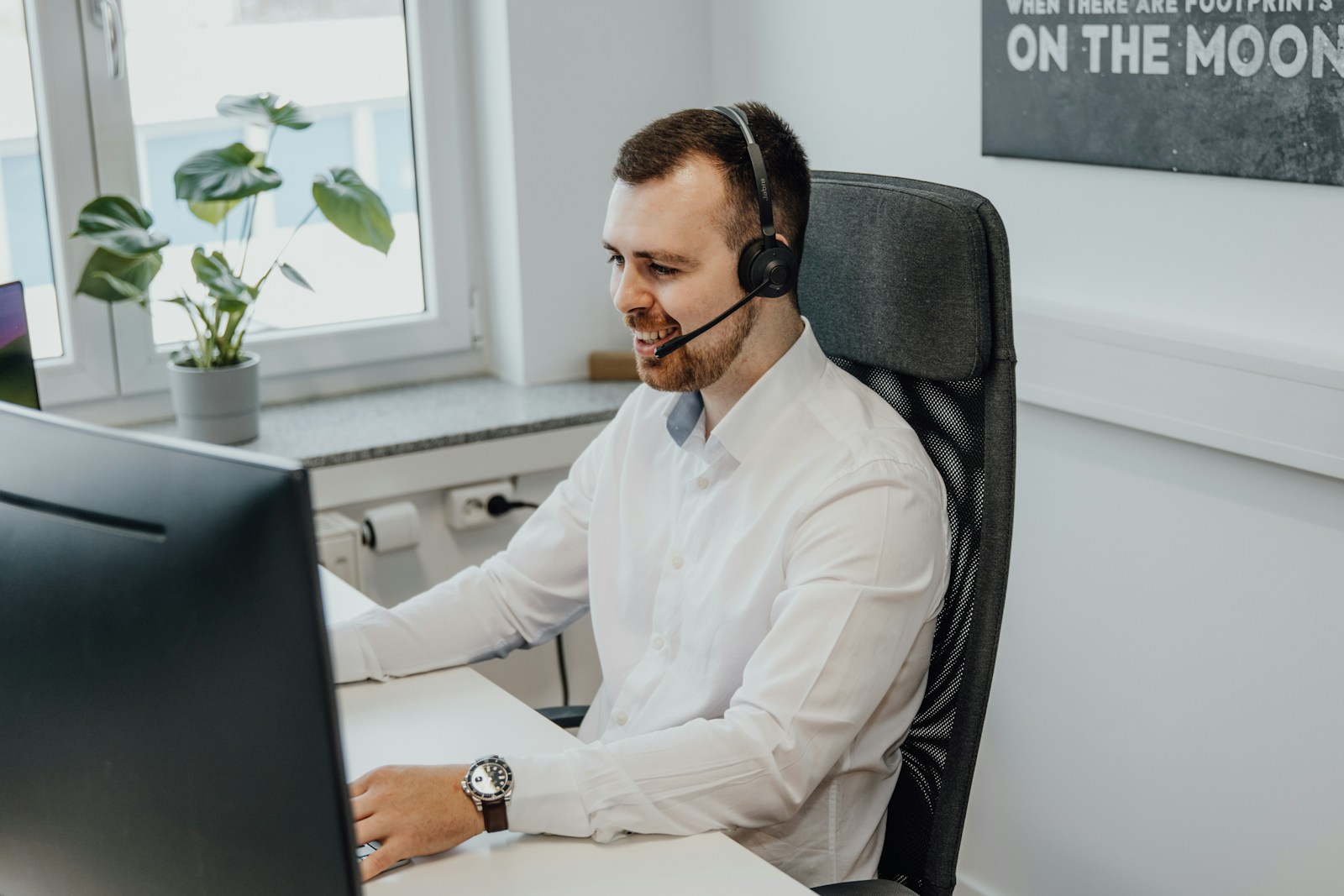 un homme portant un casque assis devant un ordinateur