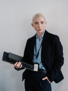 Femme d'affaires confiante en tenue formelle tenant un dossier noir à l'intérieur.