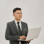 Un homme d'affaires tient un ordinateur portable et lève les yeux.