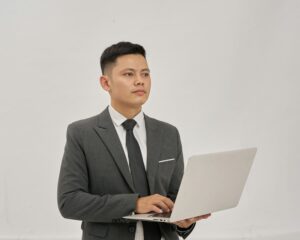 Un homme d'affaires tient un ordinateur portable et lève les yeux.