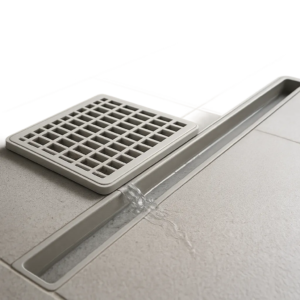 Illustration d’une grille en plastique qui retient les débris avant la canalisation. Une scène claire et moderne pour montrer son rôle ضد bouchons et mauvaises odeurs.