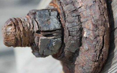 Boulon rouillé et fissuré, fixé sur planche de bois, texture détériorée