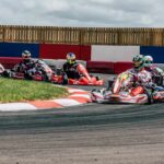 Plusieurs pilotes en karting négocient un virage serré sur circuit