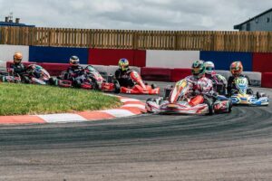 Plusieurs pilotes en karting négocient un virage serré sur circuit