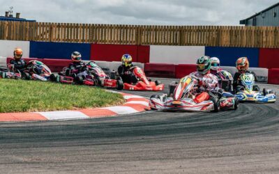 Plusieurs pilotes en karting négocient un virage serré sur circuit