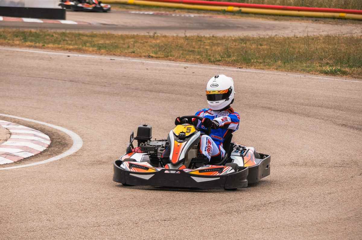 Kart de course avec pilote sur une piste de karting Kart de course avec pilote sur une piste de karting